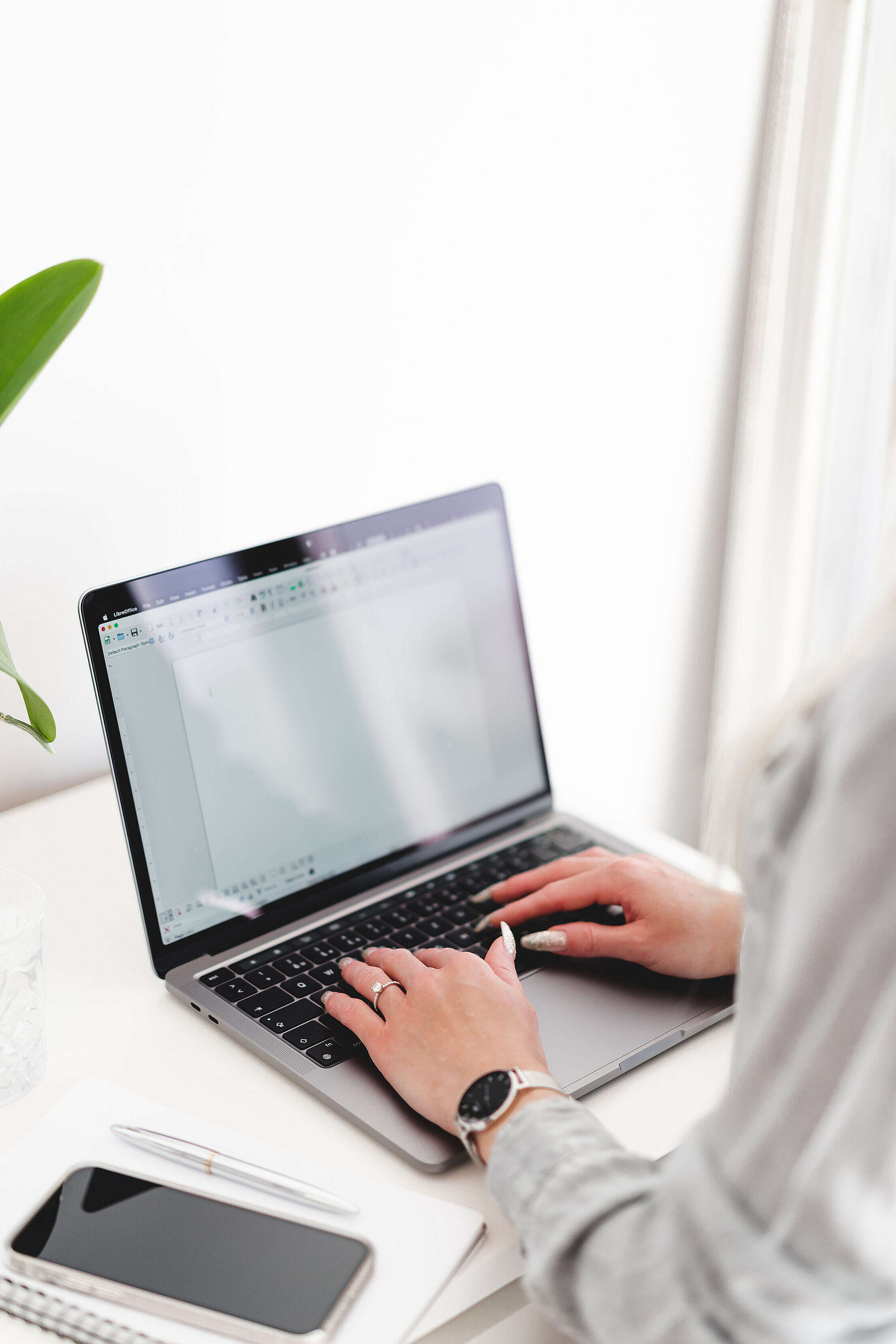 Person working on a laptop in a bright, organized workspace